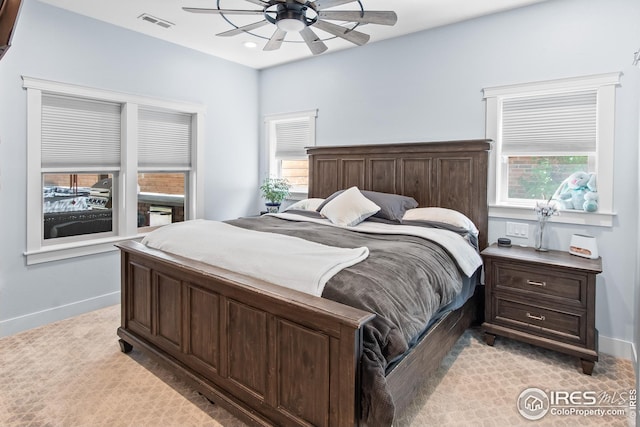 bedroom featuring baseboards, visible vents, and multiple windows