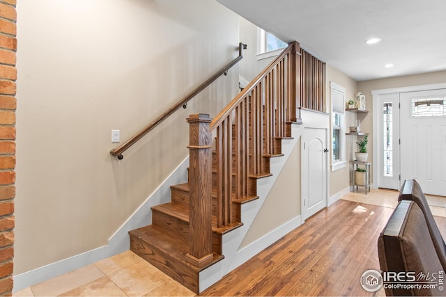 stairway with baseboards, recessed lighting, and wood finished floors
