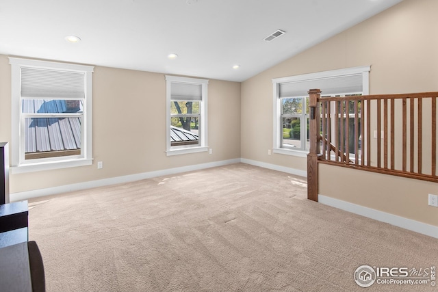 carpeted spare room featuring recessed lighting, baseboards, visible vents, and lofted ceiling