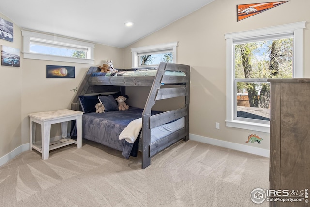 carpeted bedroom with baseboards and lofted ceiling