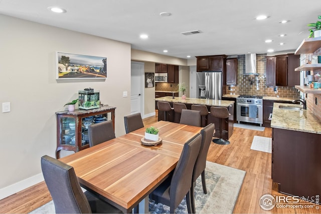 dining room featuring recessed lighting, baseboards, visible vents, and light wood finished floors