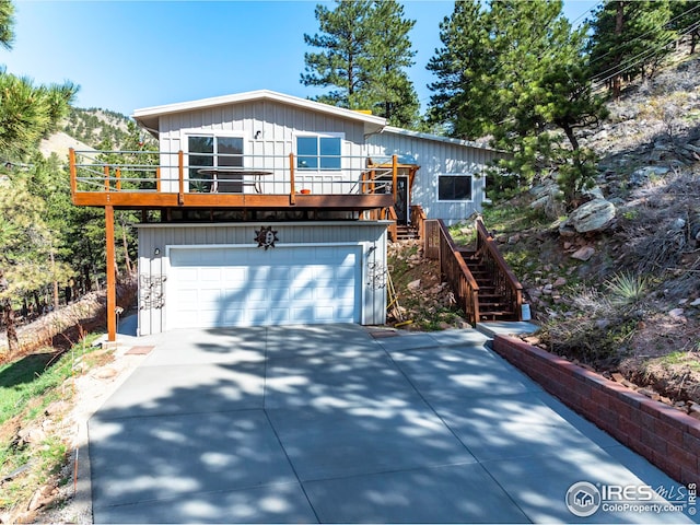 view of front of property with a garage, concrete driveway, and stairway