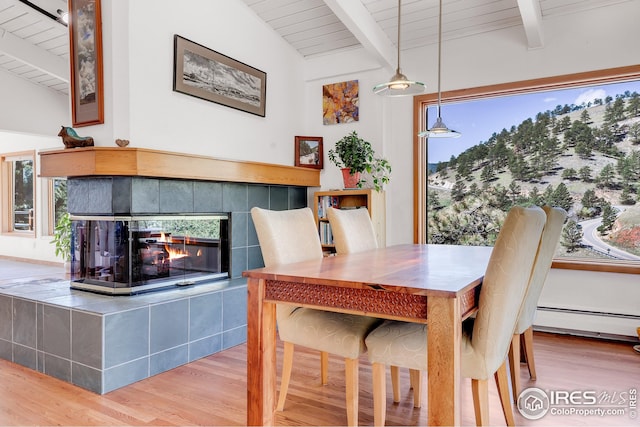 dining room with vaulted ceiling with beams, wood finished floors, and wooden ceiling