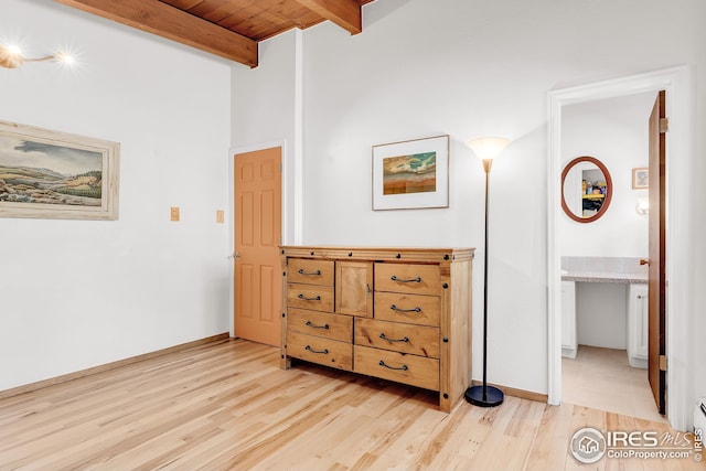 bedroom with wood ceiling, beam ceiling, baseboards, a baseboard radiator, and light wood finished floors