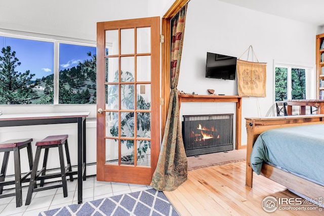 tiled bedroom with baseboard heating and a fireplace