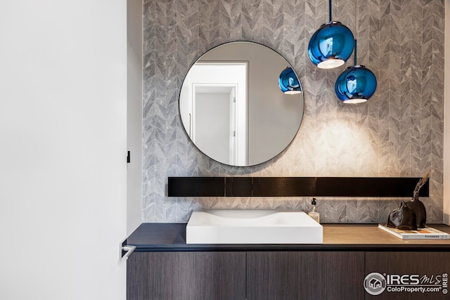 bathroom with a sink and wallpapered walls