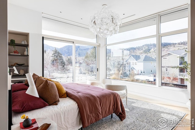 bedroom with an inviting chandelier and wood finished floors