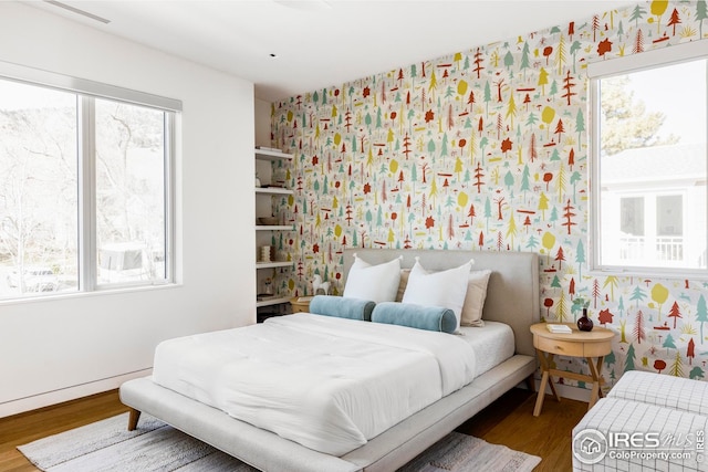 bedroom featuring wallpapered walls and multiple windows