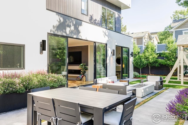 back of property featuring an outdoor living space with a fire pit, outdoor dining space, and a patio area