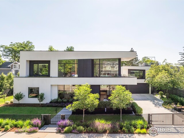 contemporary house featuring a gate, a fenced front yard, and stucco siding