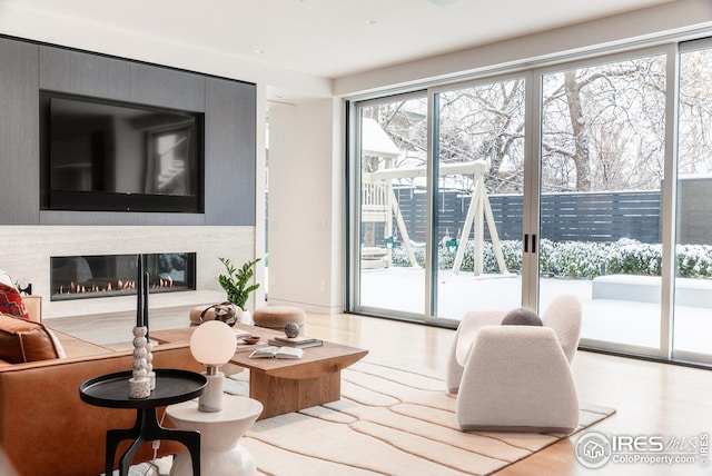 living room featuring a healthy amount of sunlight, a fireplace, and wood finished floors