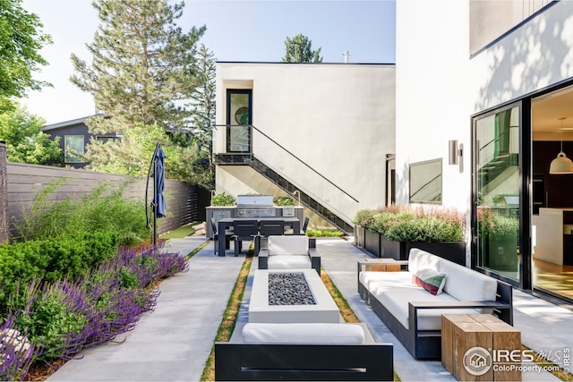 view of patio / terrace featuring a grill, fence, and an outdoor living space with a fire pit
