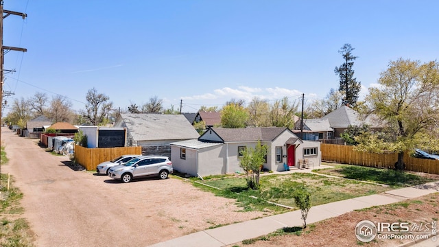 view of front facade featuring fence, a residential view, and a front lawn
