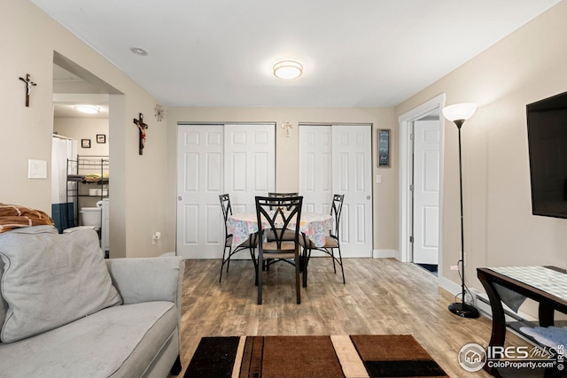 dining space featuring baseboards and light wood finished floors