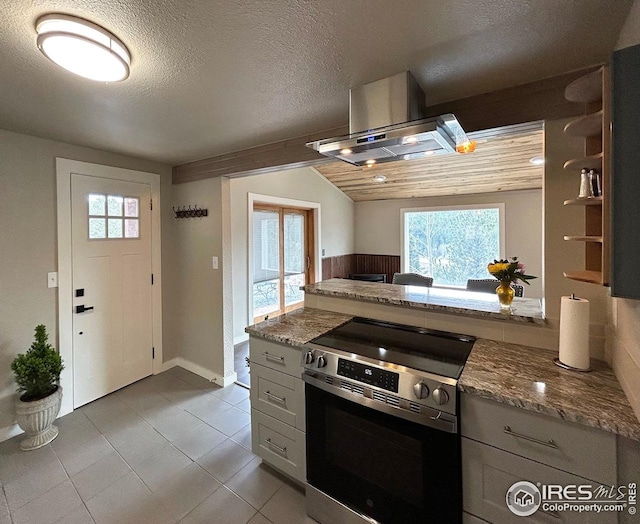 kitchen with exhaust hood, light stone countertops, light tile patterned floors, and electric stove