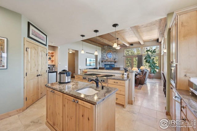 kitchen featuring light brown cabinetry, open floor plan, a center island with sink, wooden ceiling, and a sink