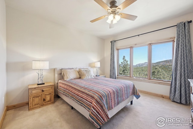 bedroom featuring baseboards, ceiling fan, and light colored carpet