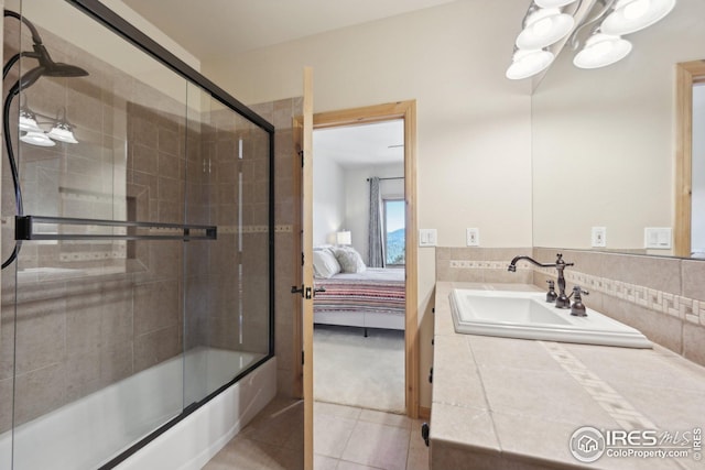 ensuite bathroom with tile patterned flooring, vanity, shower / bath combination with glass door, ensuite bathroom, and a chandelier