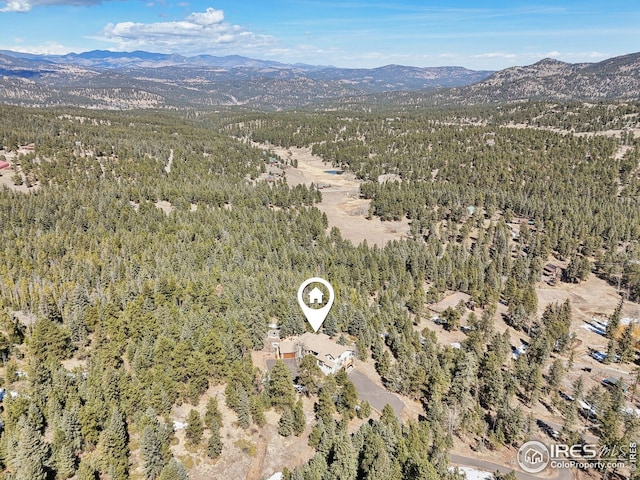 drone / aerial view with a mountain view and a forest view