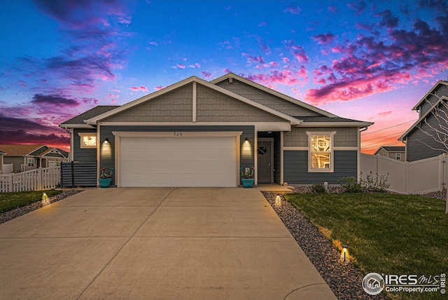 view of front of home featuring fence, an attached garage, driveway, and a front lawn