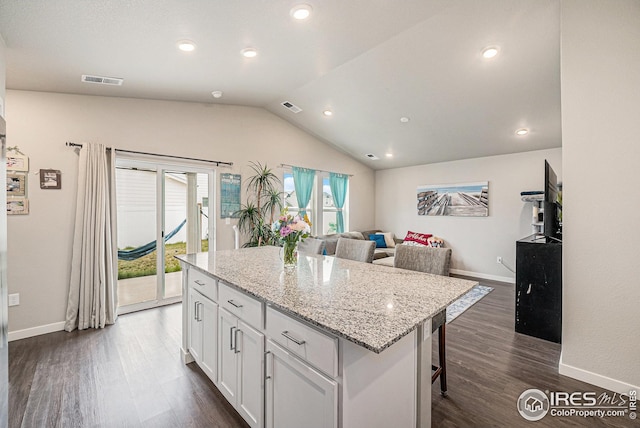 kitchen with visible vents, baseboards, vaulted ceiling, and white cabinetry