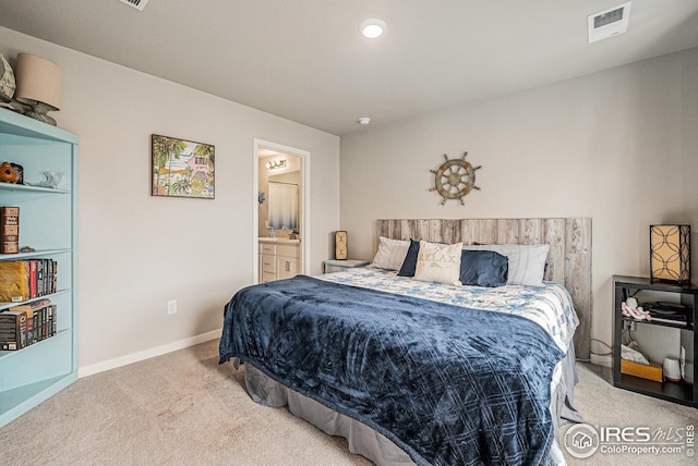 carpeted bedroom featuring baseboards, ensuite bathroom, and visible vents