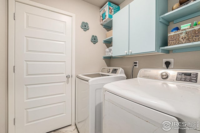 washroom with cabinet space, washer and clothes dryer, and marble finish floor