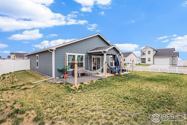 back of house featuring a lawn, a patio, and a fenced backyard