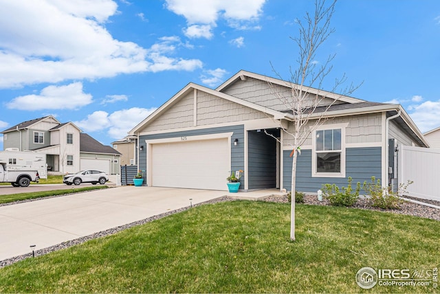 view of front of home with an attached garage, concrete driveway, and a front yard