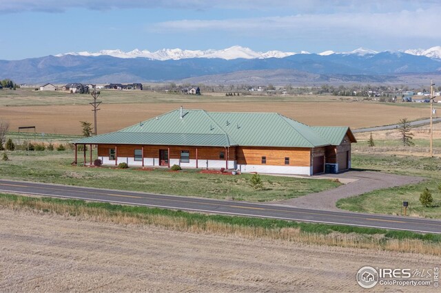 exterior space with a rural view, a mountain view, and a garage