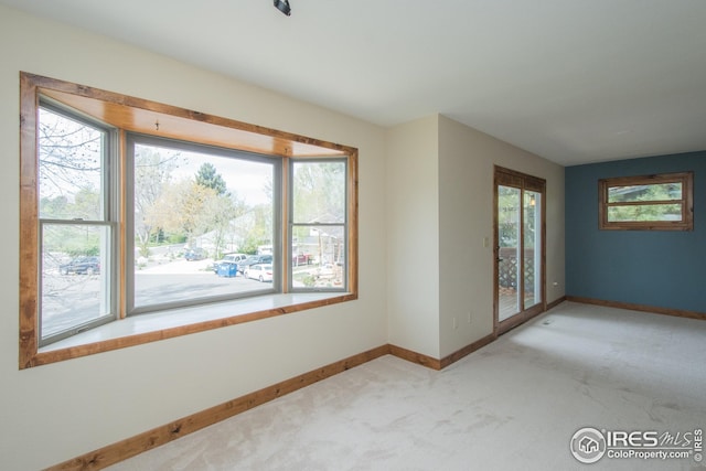 carpeted empty room with baseboards