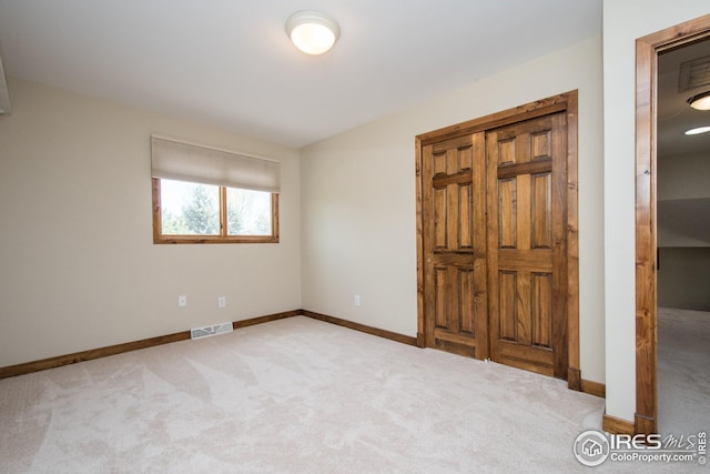 unfurnished bedroom with carpet floors, baseboards, and visible vents