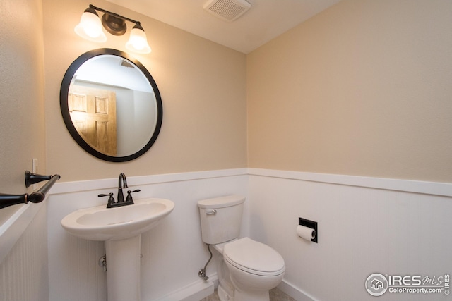 half bath with visible vents and toilet