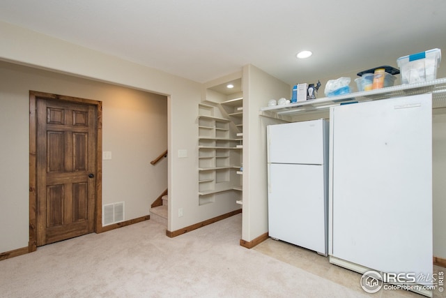 interior space featuring visible vents, freestanding refrigerator, baseboards, and white refrigerator