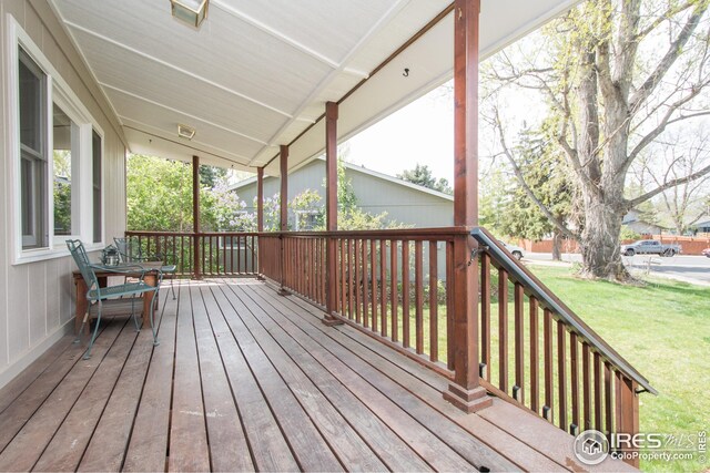 wooden deck with a lawn and a porch