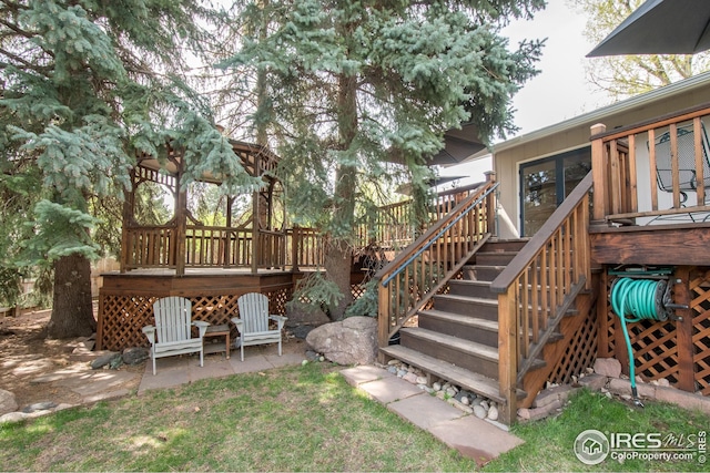 view of yard with a deck, stairs, and a patio area