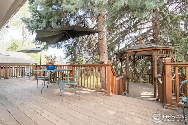 wooden terrace with outdoor dining space and a gazebo