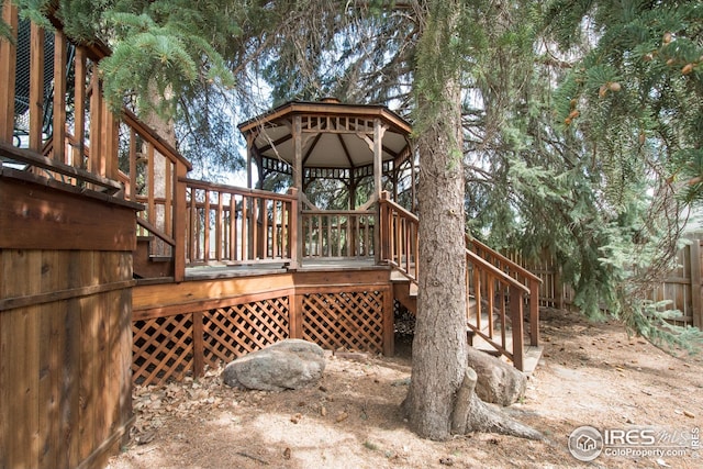 wooden deck with a gazebo, fence, and stairs