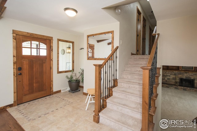 foyer featuring baseboards, stairs, light tile patterned floors, and visible vents