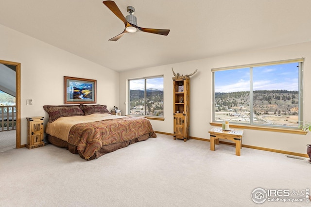 bedroom with carpet floors, baseboards, lofted ceiling, and multiple windows