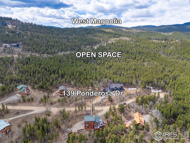 birds eye view of property with a mountain view and a forest view
