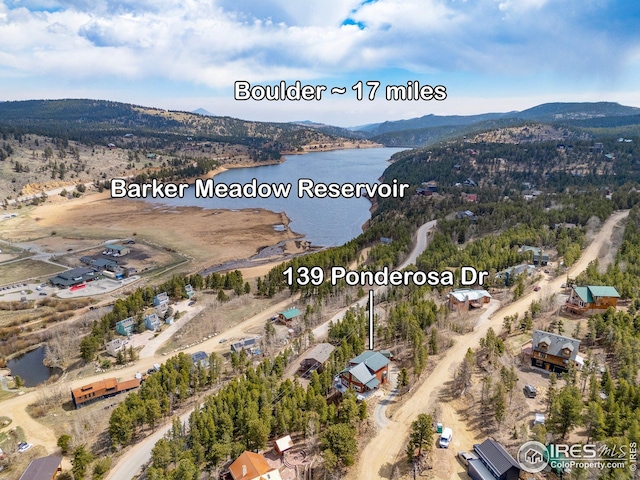 drone / aerial view featuring a water and mountain view