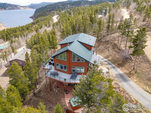 birds eye view of property featuring a water and mountain view and a wooded view