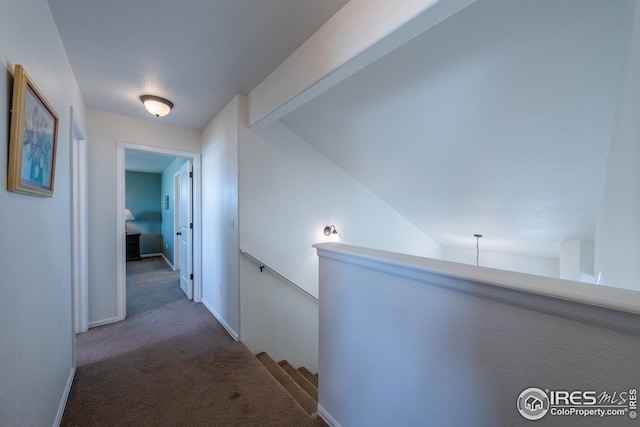 corridor with carpet floors, baseboards, and an upstairs landing
