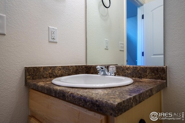 bathroom featuring vanity and a textured wall