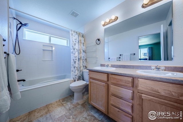 full bathroom featuring tiled shower / bath combo, toilet, visible vents, and a sink