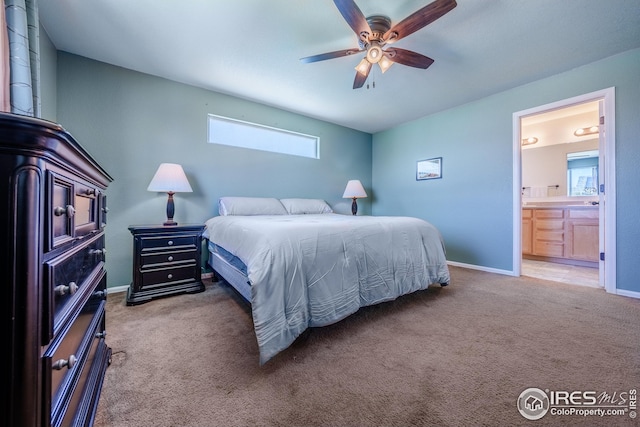 carpeted bedroom featuring connected bathroom, baseboards, and ceiling fan