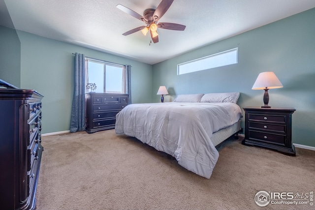 carpeted bedroom featuring baseboards and a ceiling fan