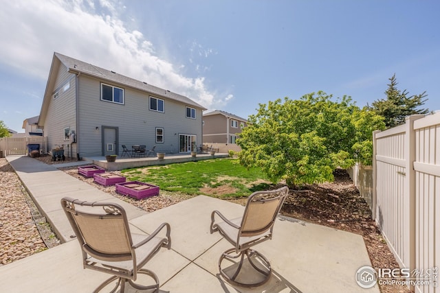 back of property featuring a lawn, a patio, and a fenced backyard