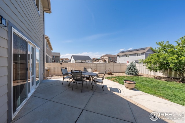 view of patio with a fenced backyard, a residential view, and outdoor dining space